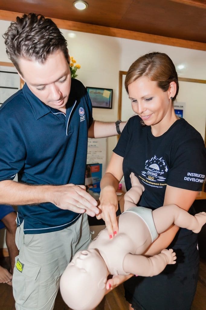 EFR Instructor training at Sairee Cottage Diving on Koh Tao, with Marcel van den Berg guiding a candidate through infant CPR practice.