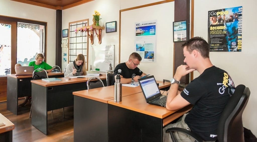 PADI IDC candidates studying scuba diving theory and instructor development materials in a classroom at Sairee Cottage Diving